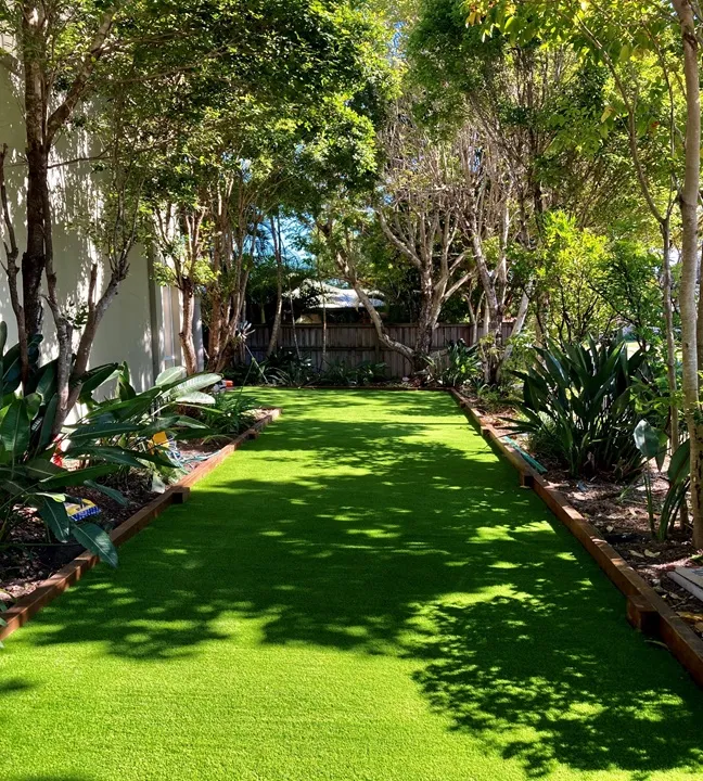 The same garden before and after Lscapes replaced the patchy lawn with artificial turf and a timber garden edge